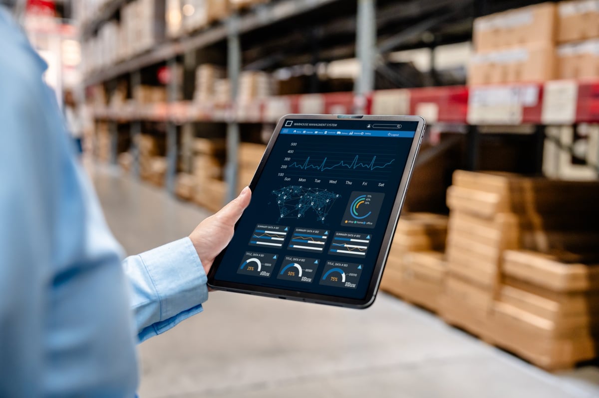 Logistics professional monitoring warehouse and delivery operations on a digital dashboard